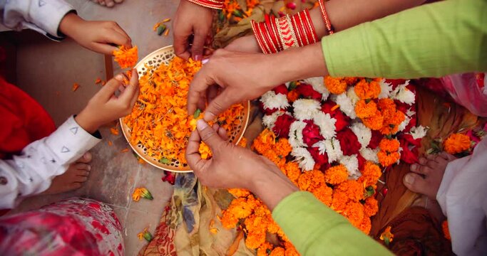 Slow-motion close-up portrait of a family- husband wife with two children, daughter son, decorate celebrate enjoy play traditional Hindu festival of lights - Diwali with flowers candles in India