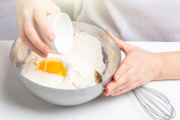 Mom and kid son kneading dough for sweet pastries, cookies. Cooking dough for baking in home kitchen. Preschooler skills, little helper. Family pastime. Adding ingredients