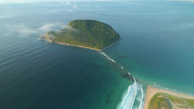 Petrov Island Russia Primorsky Territory among blue sea covered with fog. Above morning clouds spectacular aerial natural landscape. Marine reserve wild untouched epic seascape. Lonely island. Sunny