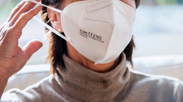 Corona Schutzmaske / FFP2 Atemschutzmaske / Frau / Maske aufsetzen / Freizeit
