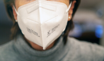 Corona Schutzmaske / FFP2 Atemschutzmaske / Frau / Maske aufsetzen / Büro