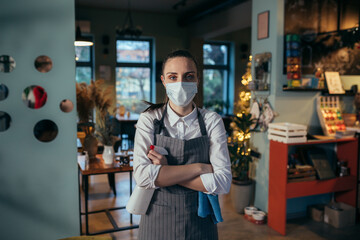 Obraz na płótnie Canvas waitress cleaning tables in restaurant. corona virus concept