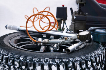 pump and other equipment for changing car tires on a winter background