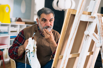 senior man painting picture at home