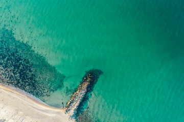 Sea coastline with big waves, above view, beach  background. Ocean surface seashore, pier