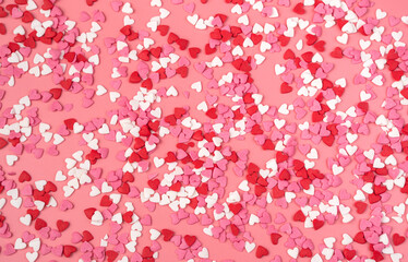 Lots of little hearts on a pink background. Top view, romantic background.