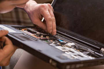 Fototapeta premium Wizard repairs laptop with tools and hands