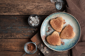 Obraz na płótnie Canvas Cookies sprinkled with cocoa on a wooden background.