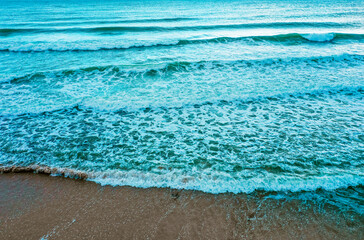 Sea coastline with big waves, above view, beach background. Ocean surface seashore, storm water.
