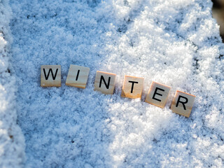 Winter - napis z drewnianych kostek, ułożony w śniegu, pora roku, język angielski 