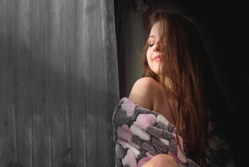 Fototapeta premium Young cute Young cute girl at the evening windowgirl at the evening window
