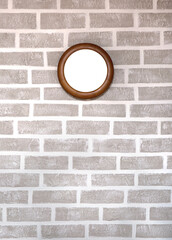 Wood round frame on grey brick wall background.