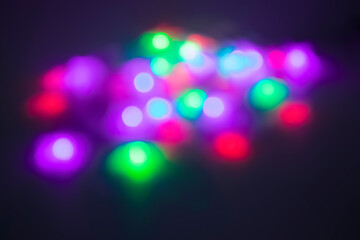 Christmas garland of colorful stars on purple background. Christmas and New Year concept. Defocus.