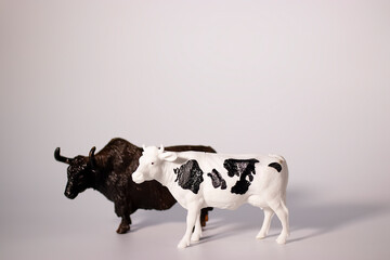 Two decorative figurines of a bull and a cow on a white background. Christmas and New Year concept.