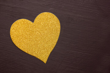 Yellow heart on a black background. View from above. Hearts are in the middle. The concept of Love. Valentine is Day. Romance. Background. Texture. Copy space. Flatlay.