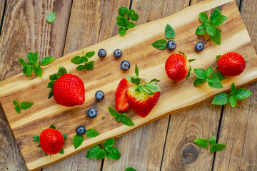Ripe strawberries and blueberries and mint leaves