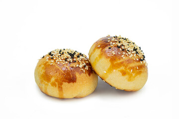 Two freshly baked buns with sesame and black cumin on isolated white background