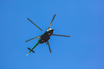 Fototapeta na wymiar Helicopter flying against the blue sky, transport