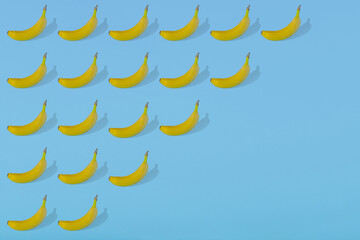 Trendy Summer pattern with fresh banana fruit on bright light blue background