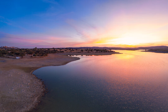 Drone aerial panorama of a dam lake reservoir with a camper van at sunset in Terena, Portugal