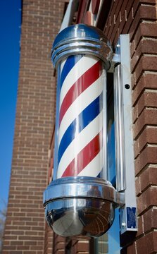 Barber's pole outside a mens barber shop close-up.