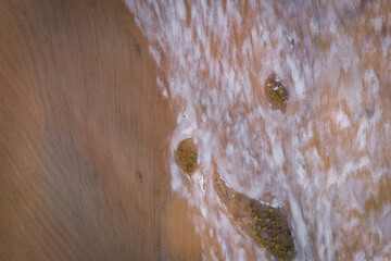 Fototapeta premium Drone top aerial panorama of a desert like hill landscape with marble stones dust at sunset in Terena near a dam lake reservoir, Portugal