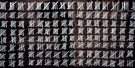 Counting stripes calendar. Handmade tally marks written on the wall by white chalk. Endless ...