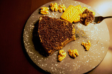 Portion of chocolate cake with chocolate chips, almonds and cookies