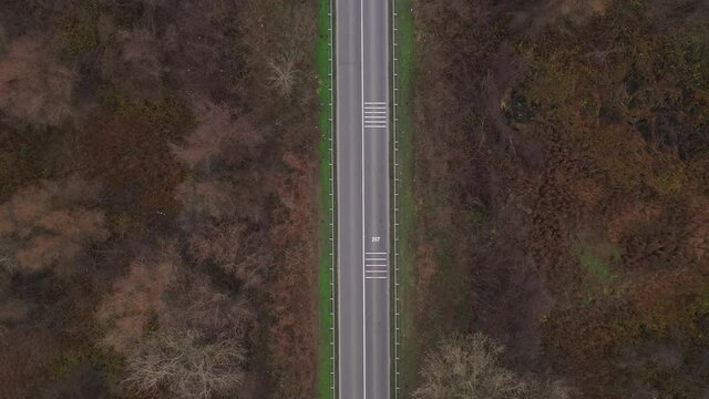 Aerial view of empty road through countryside in late autumn, top view from drone pov - no cars and no people