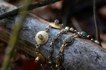 Three brass bracelets with labradorite stone on wooden background - 402044551