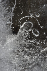 le bolle d'aria incastrate nel ghiaccio, una texture del ghiaccio che si forma sopra un torrente in montagna con molte bolle d'aria al suo interno