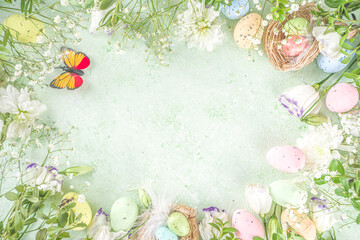 Happy Easter concept. Spring Easter holiday top view  flat lay background with easter eggs in nests and spring flowers. Easter greeting card background with copy space.