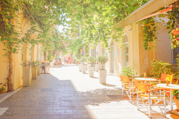 Beautiful street with restaurants in Corfu, Kerkyra island, Greece, stock photo. Street bathed in sunlight at island Kerkyra