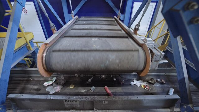 An automatic magnetic separator separates metal waste from the main waste stream on the conveyor.