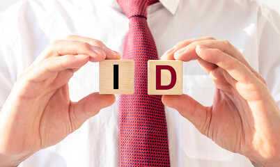 ID acronym inscription on wooden cubes in hands of man