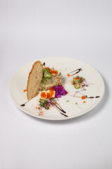 interpretation of olivier salad with grilled chicken fillet, quail eggs and red caviar, on a white background.