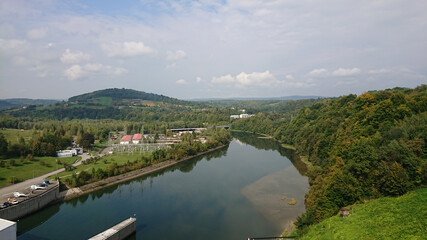 Fototapeta na wymiar Looking at the wide river flowing between the hills