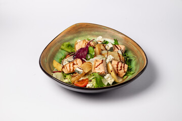 Fresh Salmon Salad with caramelized pear, feta and lettuce on a white background