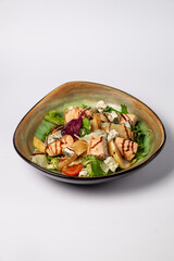 Fresh Salmon Salad with caramelized pear, feta and lettuce on a white background