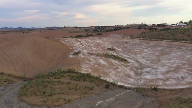 Drone aerial panorama of a desert like hill landscape with marble stones dust at sunset in Terena, Portugal