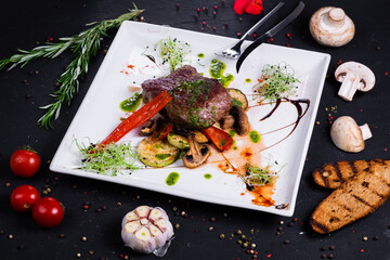 Veal mignon fillet with grilled vegetables. on a dark background