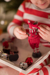 Child holds Christmas toys and bells
