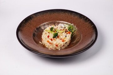 Basmati rice with fried carrots, onions, mushrooms, broccoli vegetables in butter on a white background