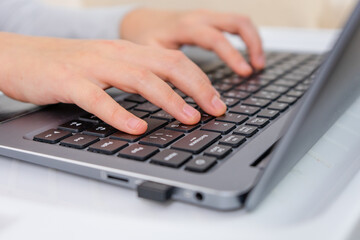 focused little kids hands pressing laptop keyboard