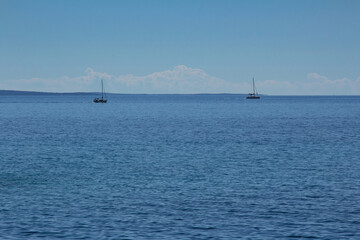 Two yachts sailing in the distance in Adriatic sea.