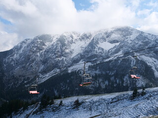 Leerer Sessellift vor verschneiten Bergen in den bayerischen Alpen in Zeiten von Covid-18