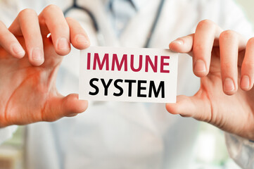 Doctor holding a card with text IMMUNE SYSTEM in hands. Medical concept