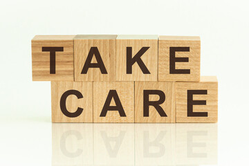 Take Care written on a wooden cube