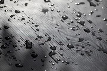 Water drops on black wooden surface