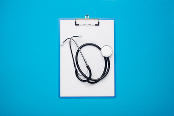 Medical stethoscope and clipboard on a blue background. Banner. Top view, flat lay